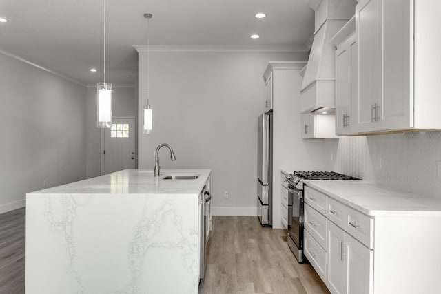 kitchen with pendant lighting, sink, a center island with sink, stainless steel appliances, and light stone countertops