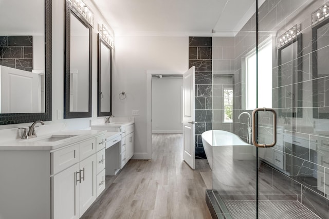 bathroom with shower with separate bathtub, vanity, hardwood / wood-style floors, and ornamental molding