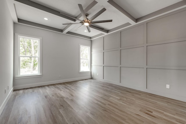 spare room featuring ceiling fan, beam ceiling, light hardwood / wood-style floors, and a wealth of natural light