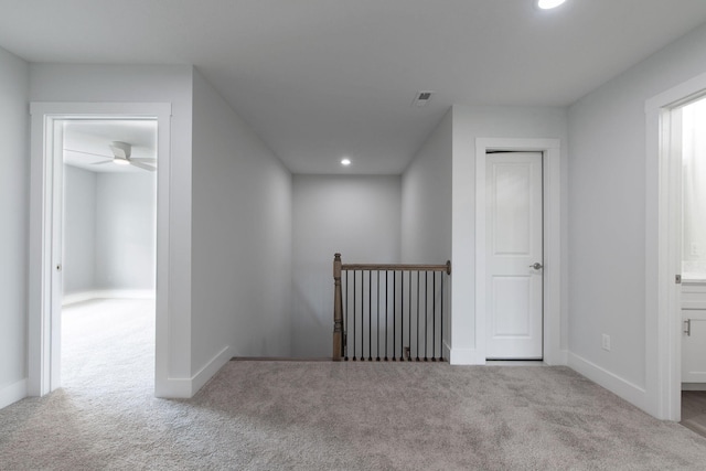 interior space with ceiling fan and light colored carpet