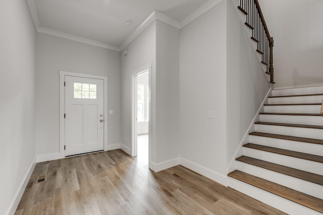 foyer featuring light wood-type flooring and crown molding