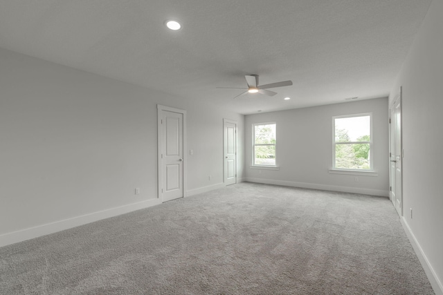 spare room with ceiling fan and light colored carpet