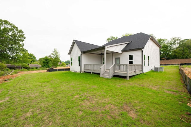 rear view of house featuring a wooden deck, a yard, and central AC