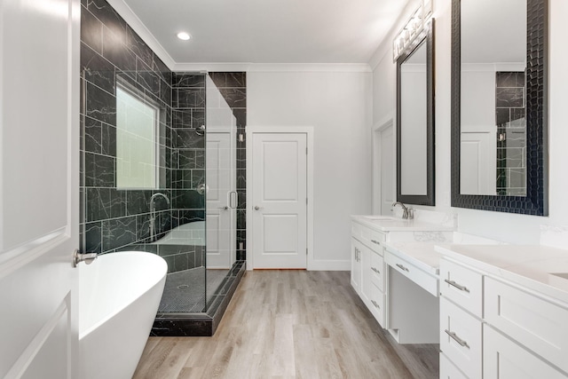 bathroom with ornamental molding, hardwood / wood-style flooring, vanity, and separate shower and tub