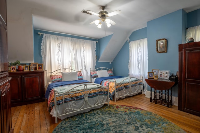 bedroom featuring hardwood / wood-style flooring, vaulted ceiling, and ceiling fan