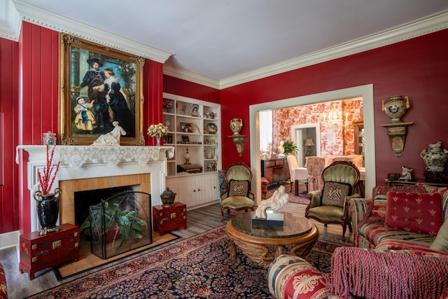 living room featuring crown molding, hardwood / wood-style floors, and a fireplace