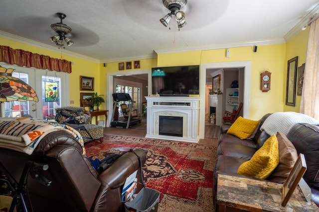 living room featuring french doors, ceiling fan, ornamental molding, and a premium fireplace