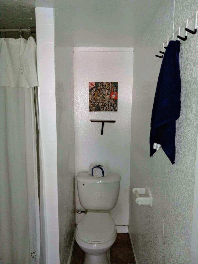 bathroom featuring toilet and walk in shower