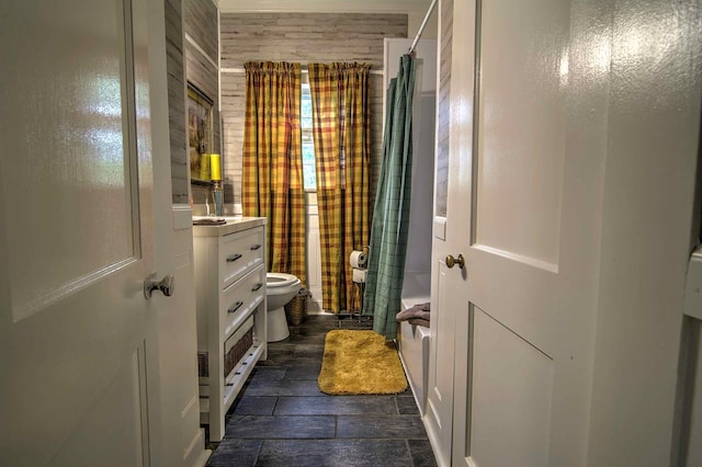 full bathroom featuring vanity, shower / tub combo with curtain, toilet, and wood walls