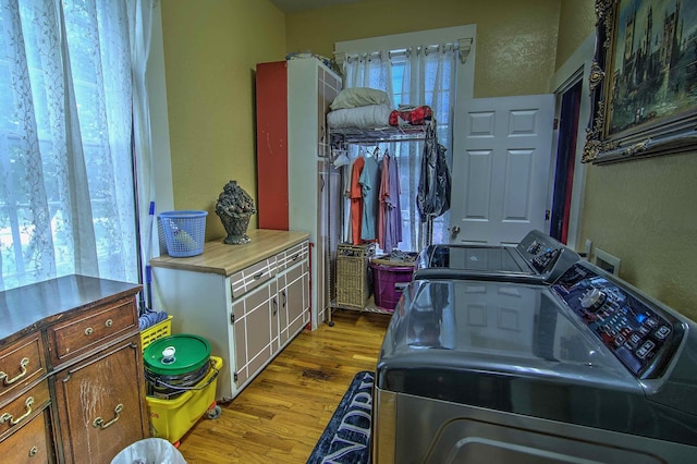 laundry area with light wood-type flooring and separate washer and dryer