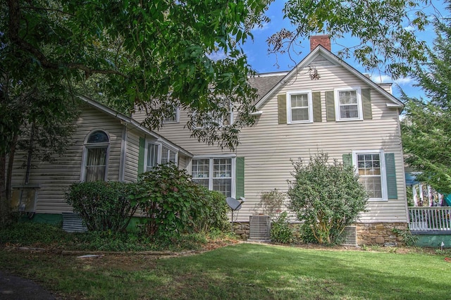 view of side of property with central AC and a lawn