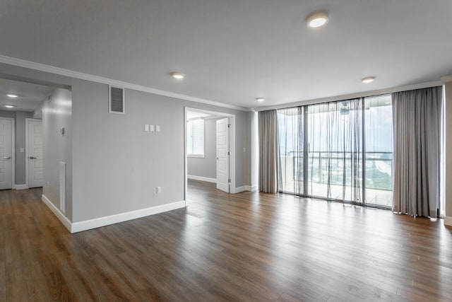 empty room featuring dark wood-type flooring, floor to ceiling windows, visible vents, and crown molding