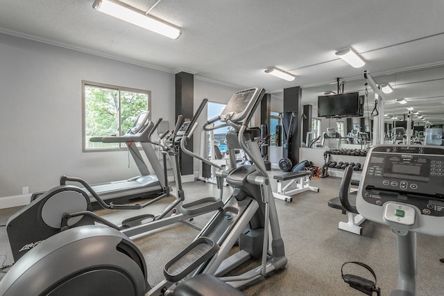 workout area featuring ornamental molding and a textured ceiling