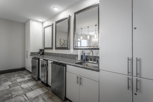 kitchen featuring white cabinetry, a sink, dark stone countertops, and fridge