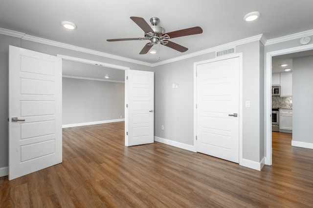 unfurnished bedroom with ornamental molding, dark wood-type flooring, and ceiling fan