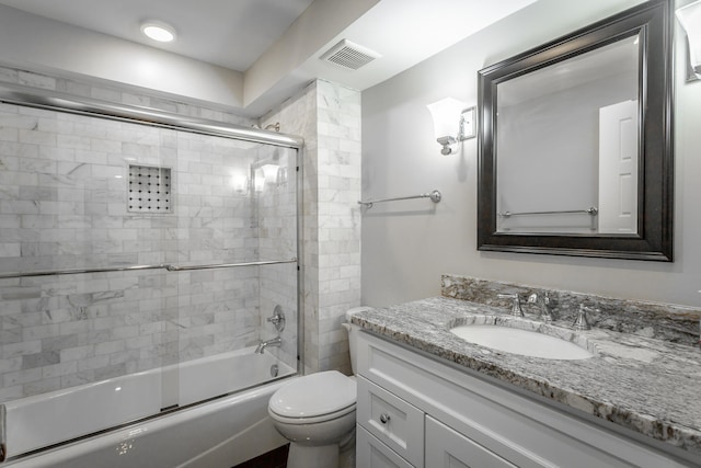 bathroom with toilet, enclosed tub / shower combo, visible vents, and vanity