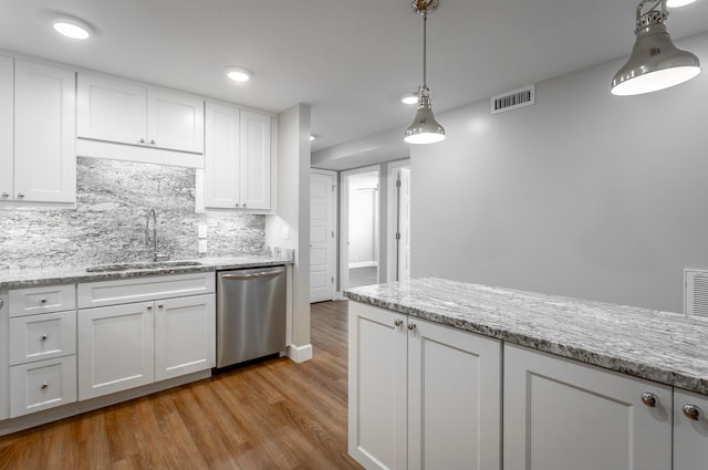 kitchen with dishwasher, a sink, and white cabinets