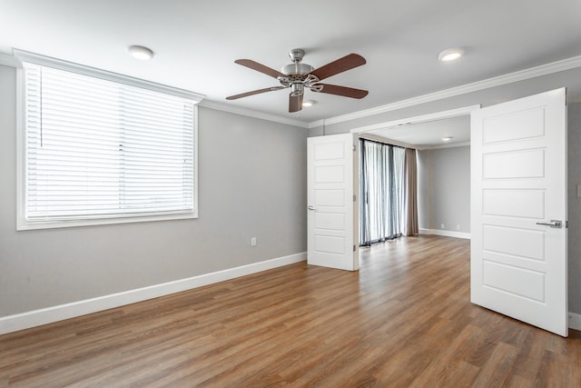 unfurnished room with ornamental molding, ceiling fan, baseboards, and wood finished floors