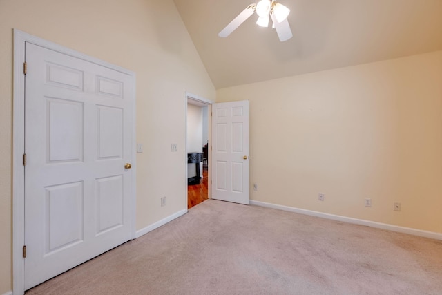 unfurnished bedroom with ceiling fan, light colored carpet, and high vaulted ceiling