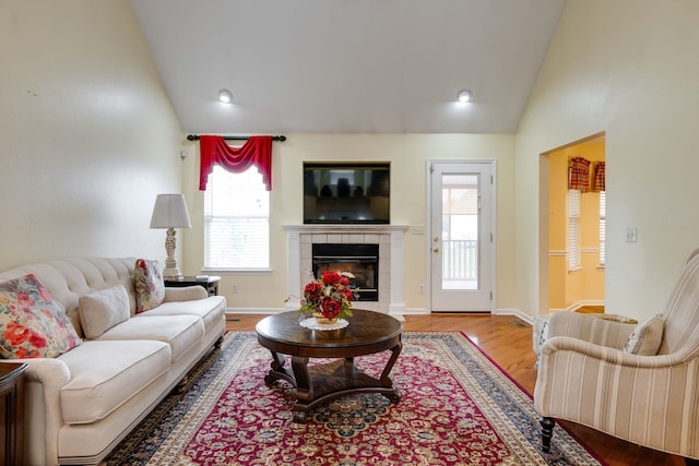 living room with a fireplace, vaulted ceiling, and hardwood / wood-style floors