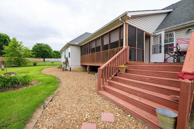 wooden deck with a sunroom and a lawn