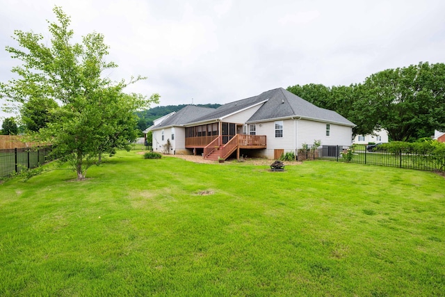 back of property featuring a wooden deck and a yard