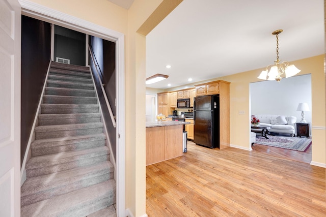 staircase featuring hardwood / wood-style floors and a notable chandelier