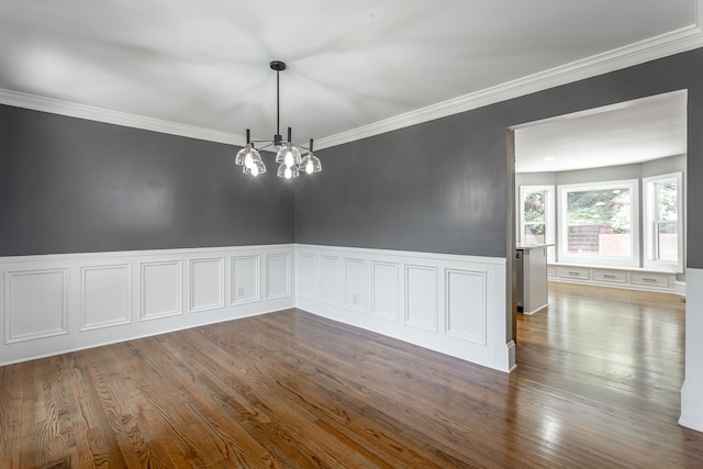 spare room with ornamental molding, a notable chandelier, and hardwood / wood-style flooring