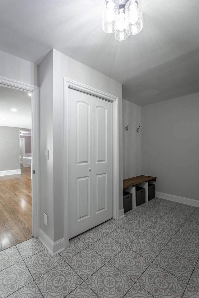 mudroom with hardwood / wood-style floors and an inviting chandelier