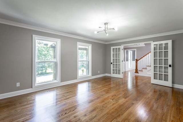 unfurnished room featuring french doors, hardwood / wood-style floors, and crown molding