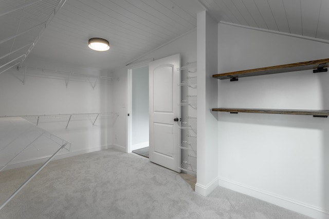 spacious closet with vaulted ceiling and light carpet