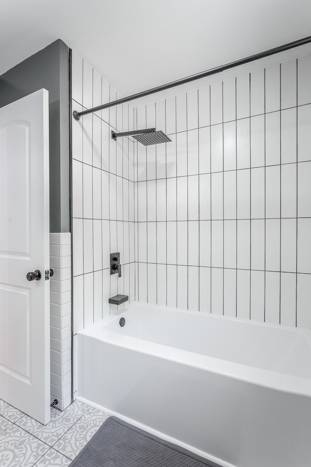 bathroom featuring tiled shower / bath combo, tile walls, and tile patterned flooring