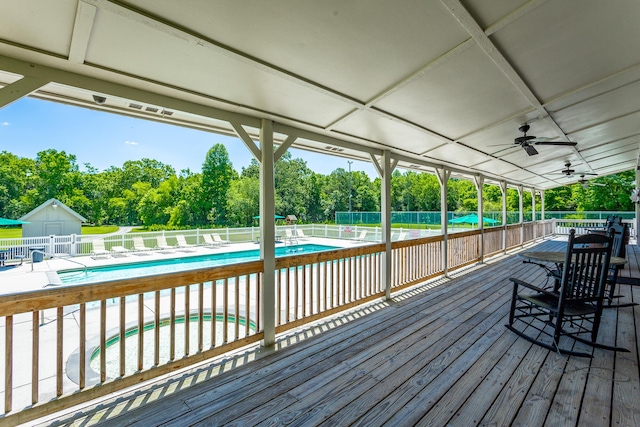 wooden terrace featuring a patio area, a community pool, and ceiling fan