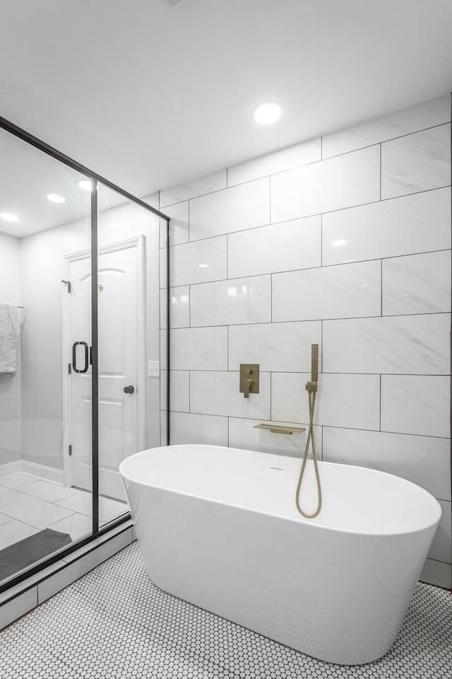 bathroom with tile walls, independent shower and bath, and tile patterned flooring