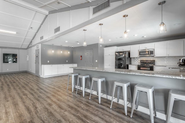 kitchen featuring a breakfast bar, white cabinetry, fridge, black electric range, and sink