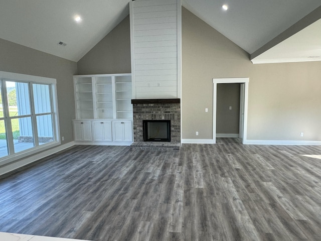 unfurnished living room featuring high vaulted ceiling and dark hardwood / wood-style flooring