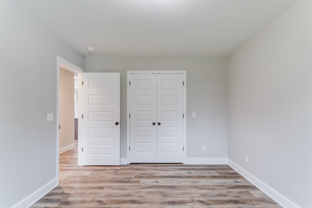 unfurnished bedroom featuring a closet and light wood-type flooring