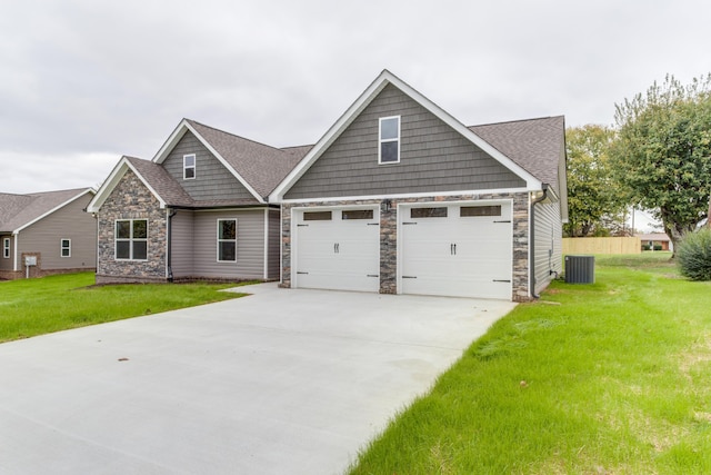 craftsman inspired home featuring cooling unit, a garage, and a front lawn