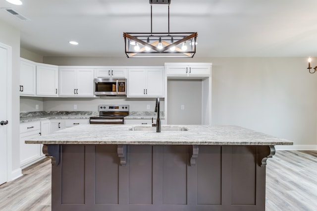 kitchen with sink, stainless steel appliances, an island with sink, light hardwood / wood-style floors, and white cabinets