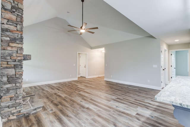 unfurnished living room featuring hardwood / wood-style floors, ceiling fan, and vaulted ceiling