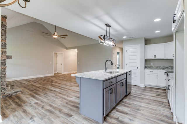 kitchen featuring white cabinetry, a kitchen island with sink, lofted ceiling, and sink