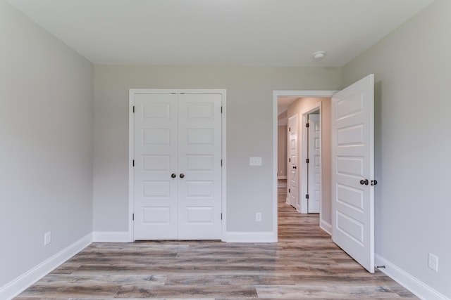 unfurnished bedroom featuring a closet and light hardwood / wood-style floors