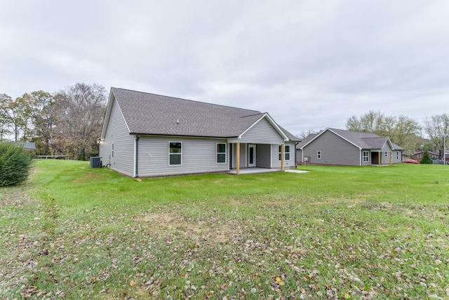 back of property with a lawn, a patio area, and central AC