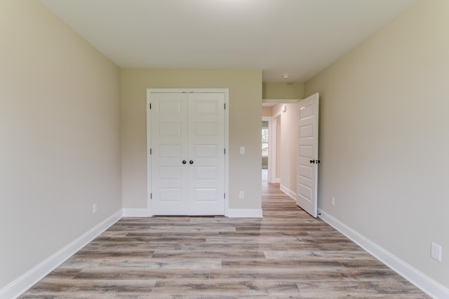 unfurnished bedroom featuring a closet and light wood-type flooring