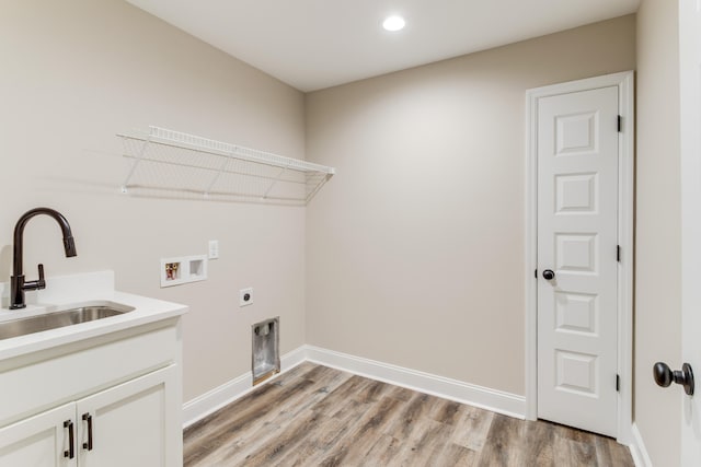 laundry room featuring cabinets, hookup for a washing machine, light wood-type flooring, hookup for an electric dryer, and sink