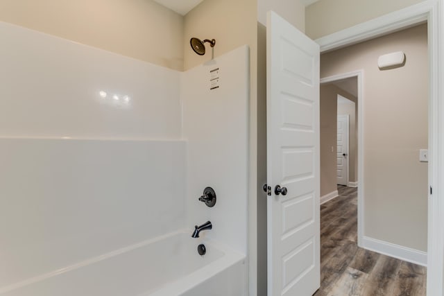 bathroom with hardwood / wood-style flooring and shower / bathing tub combination