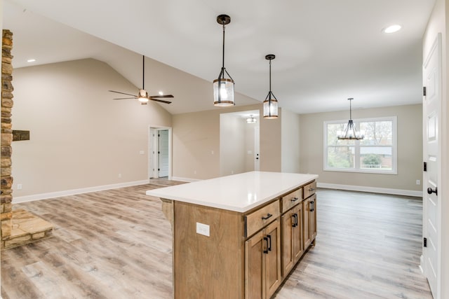 kitchen featuring pendant lighting, a center island, lofted ceiling, ceiling fan with notable chandelier, and light wood-type flooring