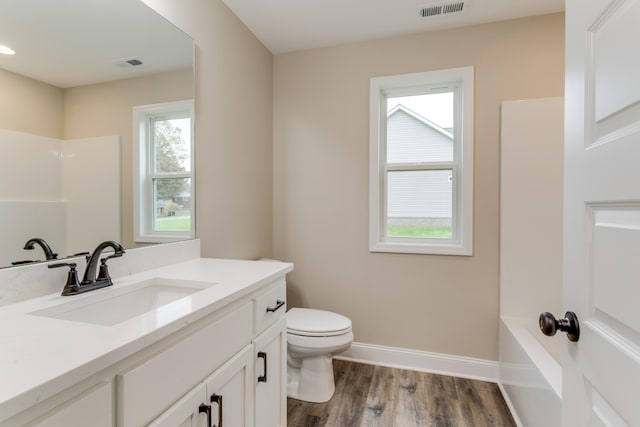 full bathroom with hardwood / wood-style flooring, vanity, toilet, and shower / bath combination