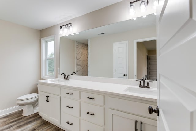 bathroom with wood-type flooring, vanity, and toilet