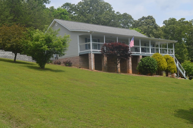 rear view of property with a balcony and a yard